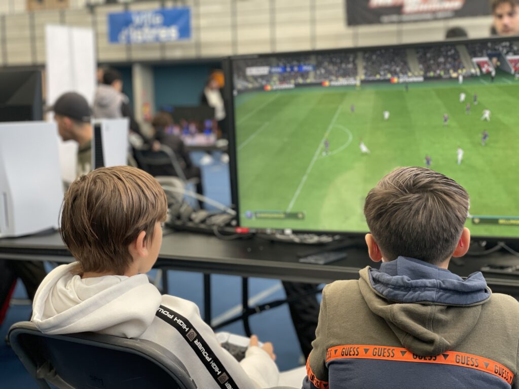 Deux jeunes qui jouent à FIFA sur une playstation 5